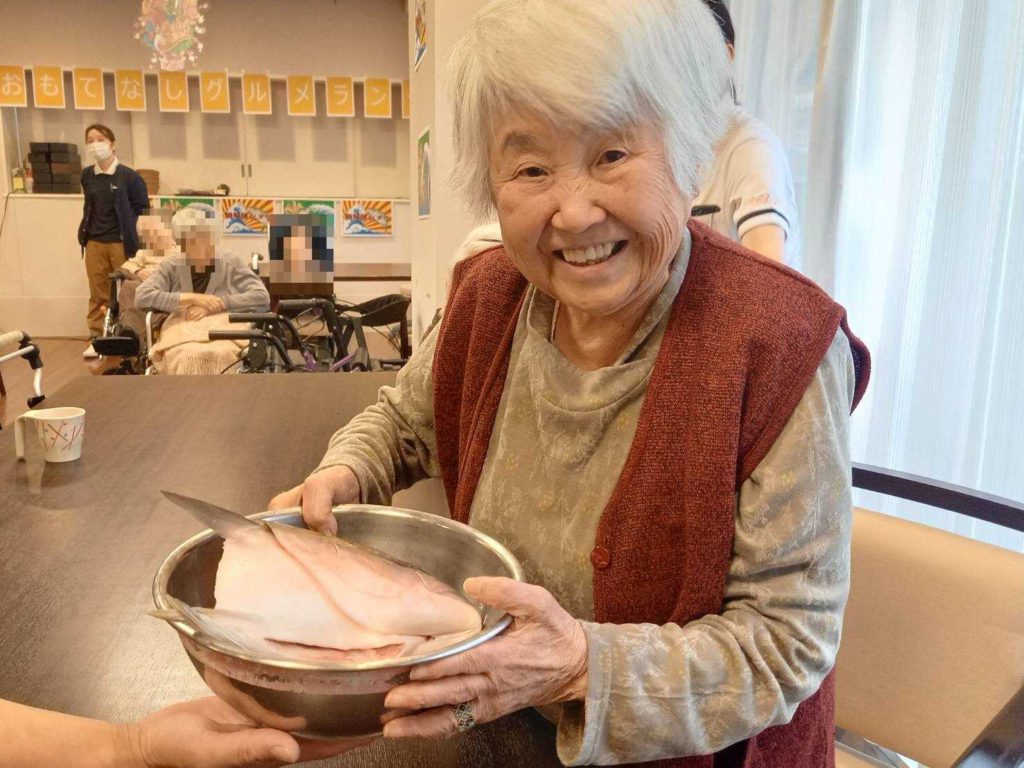 捌いたぶりの身を眺める女性