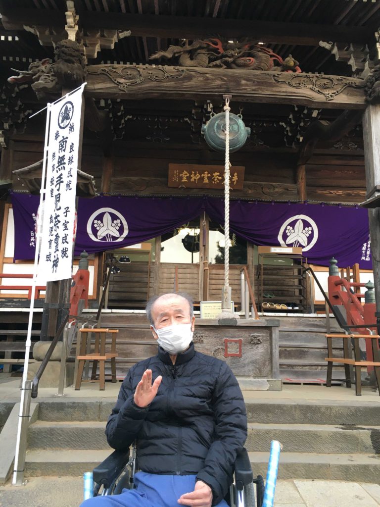 神社を背景にした男性