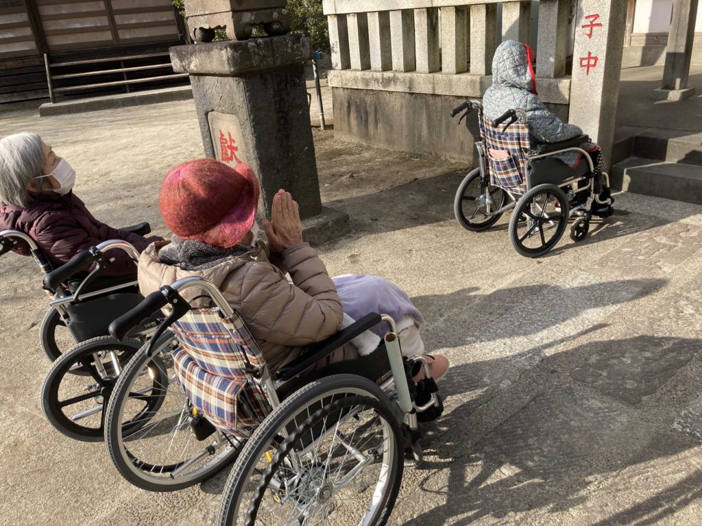 車椅子に乗って参拝する3名