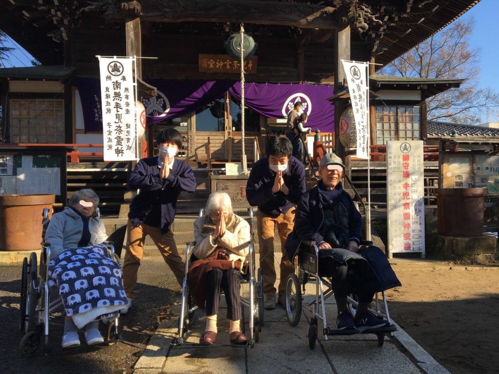 神社を背景にした5名