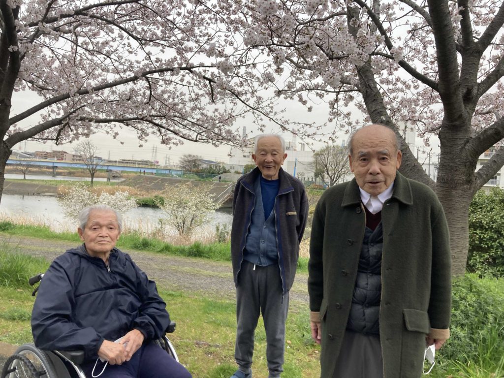 桜と写る男性3人