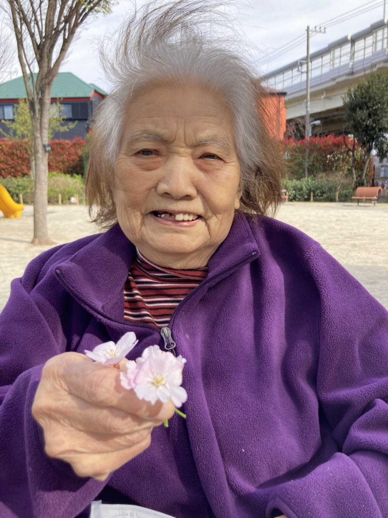 桜の花びらを見せてくれる女性